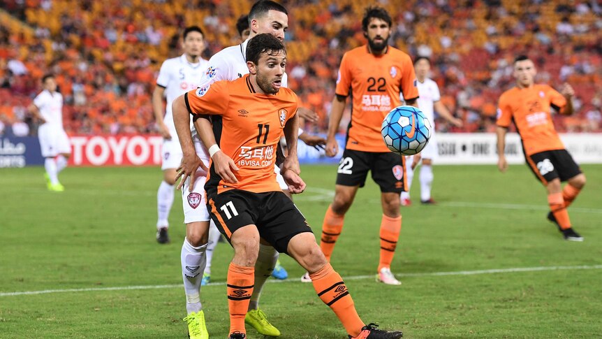 Brisbane Roar player Tommy Oar fights for the ball during his team's AFC Champions League match with Muangthong United.
