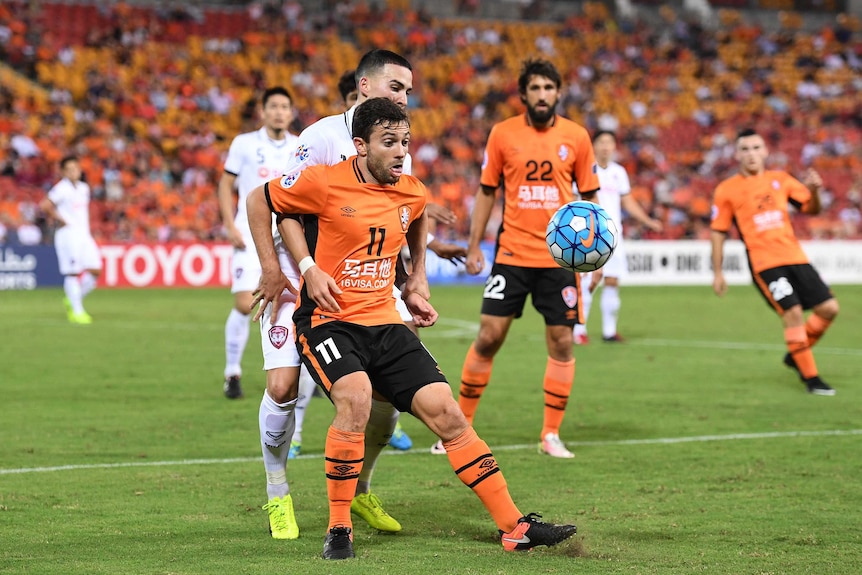 Brisbane Roar player Tommy Oar fights for the ball during his team's AFC Champions League match with Muangthong United.