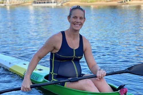 A visibly pregnant Alyce Wood in a kayak, smiling for the camera.