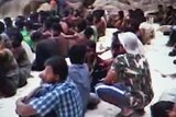 Rohingya asylum seekers sit on beach