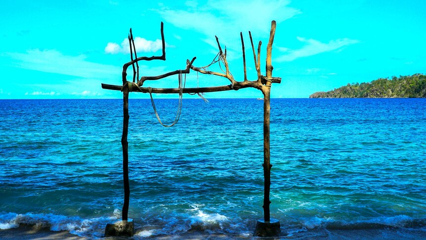 Driftwood constructed into a frame in the shallows of an Indonesian beach