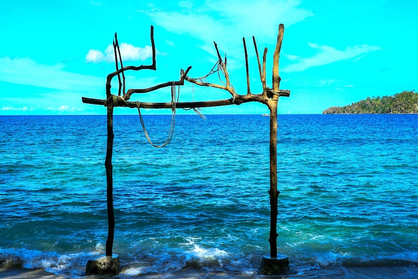 Driftwood constructed into a frame in the shallows of an Indonesian beach