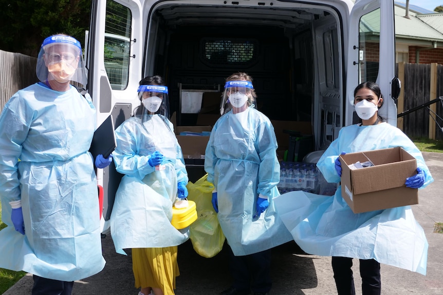 Four health workers wearing personal protective equipment.