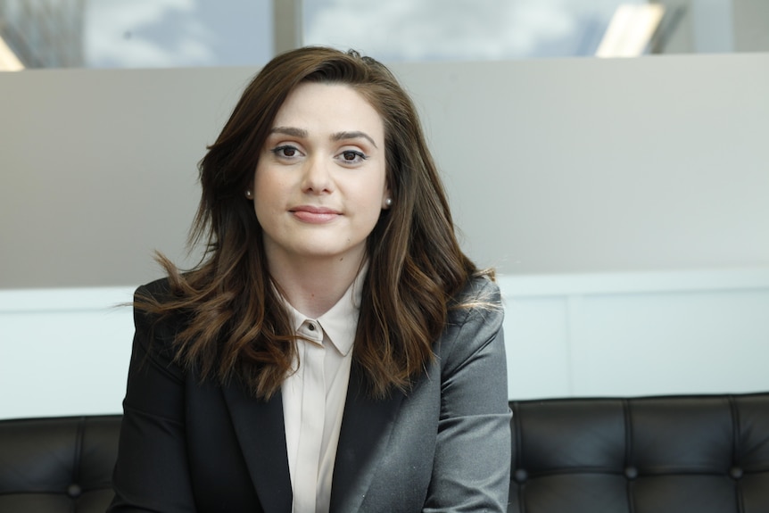 Head and shoulders image of a woman with brown hair in suit jacket.