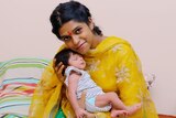 Divya Gagula smiling and holding her daughter Shaivi when she was a newborn