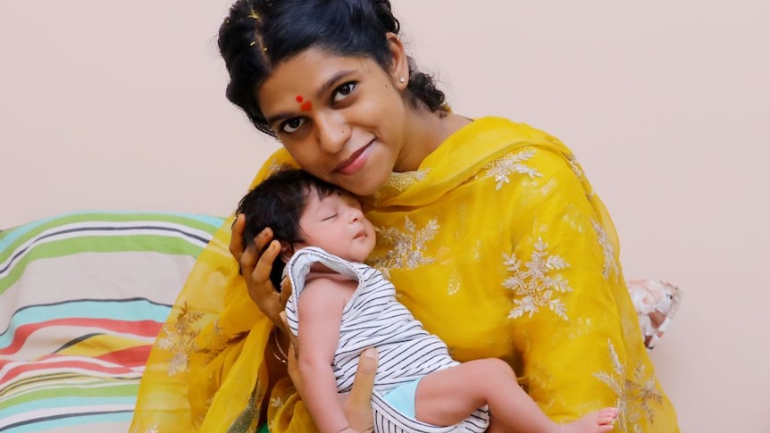 Divya Gagula smiling and holding her daughter Shaivi when she was a newborn