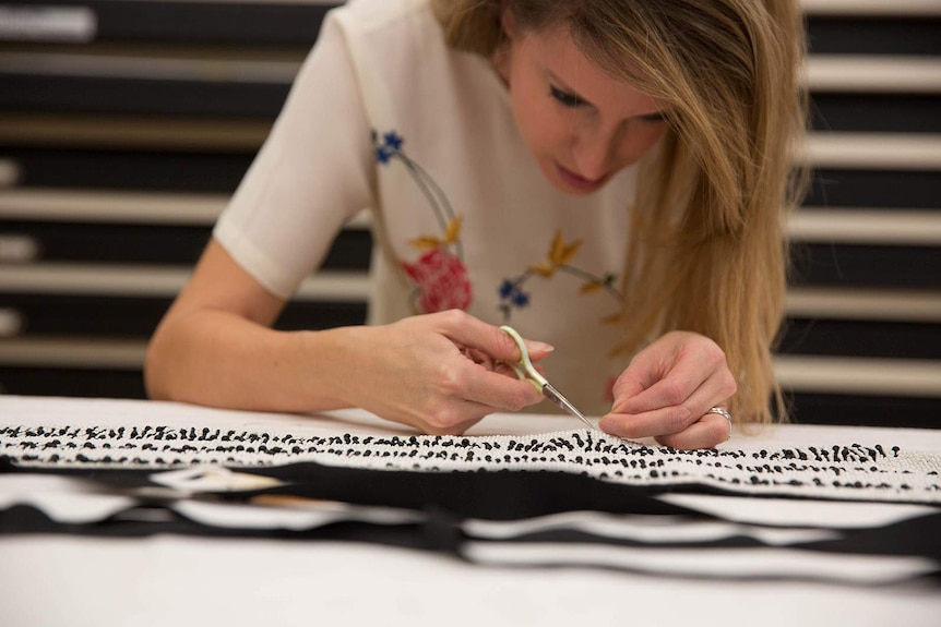 A woman with her head down focused on sewing