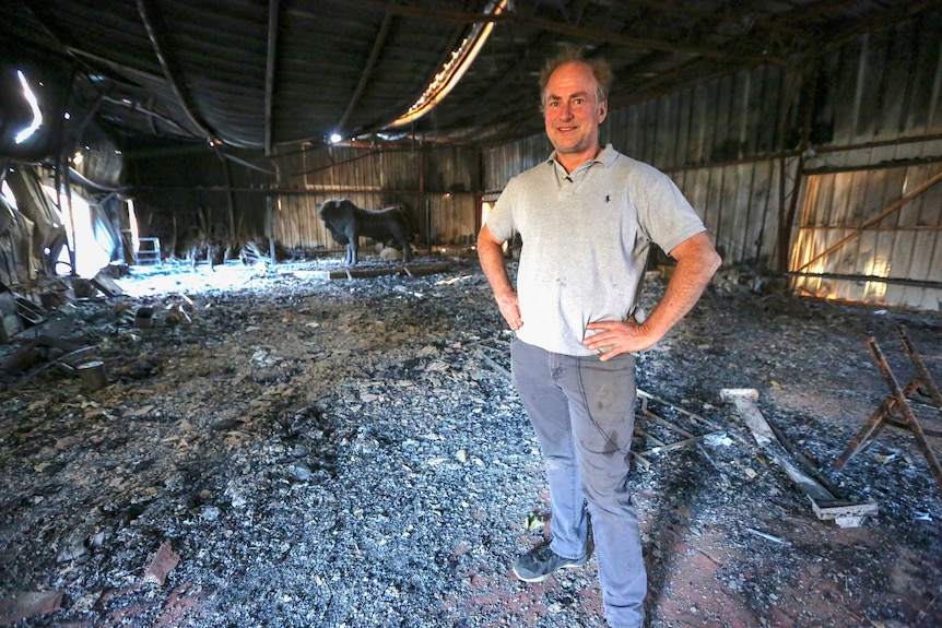 The barn floor is covered in rubble and ash.