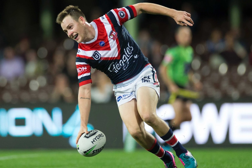 Luke Keary smiles as he grounds the ball with his right hand to score a try for the Roosters.