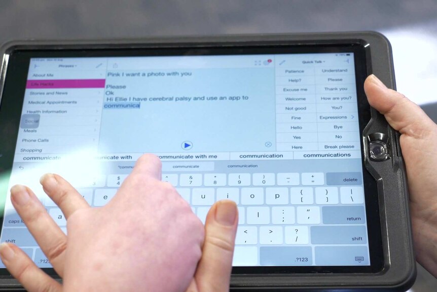 Two hands above a tablet screen covered in words.