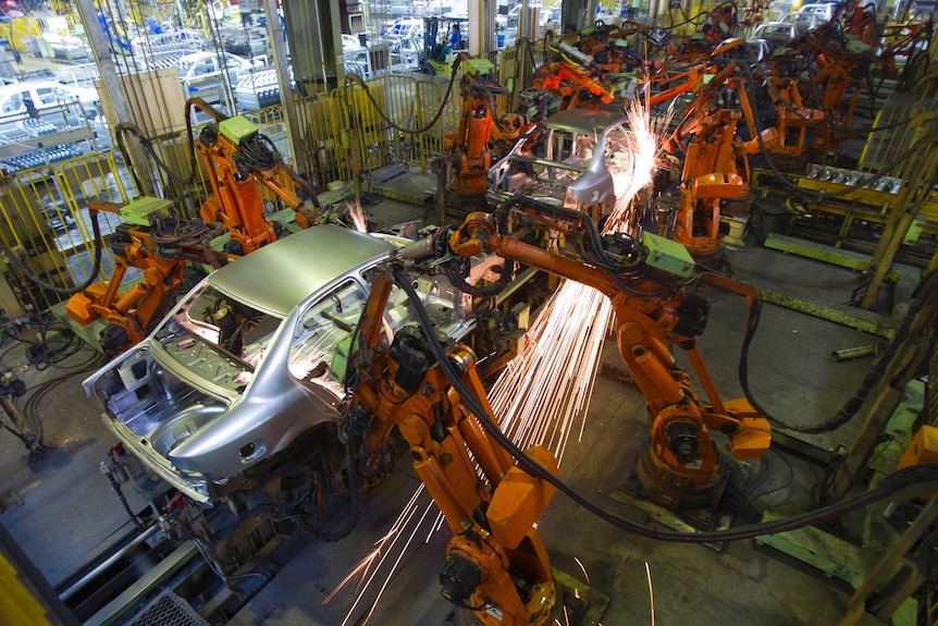 Robots work on cars in a workshop