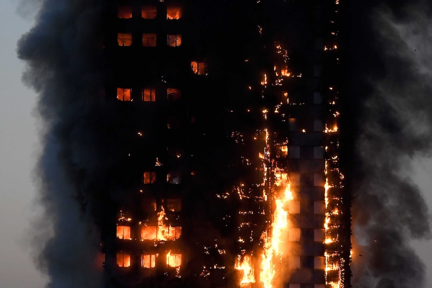 Flames and smoke billow from a burnt-out apartment building in London.