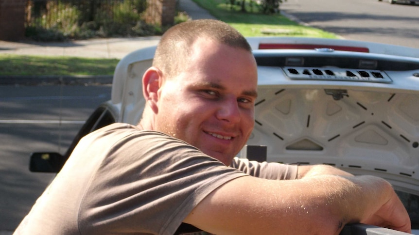 Image of Troy McLean leaning against a car.