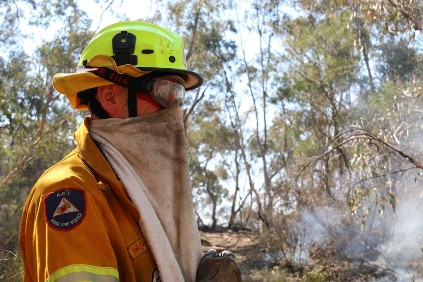A firefighter wears a towel over his nose and mouth to protect from smoke.