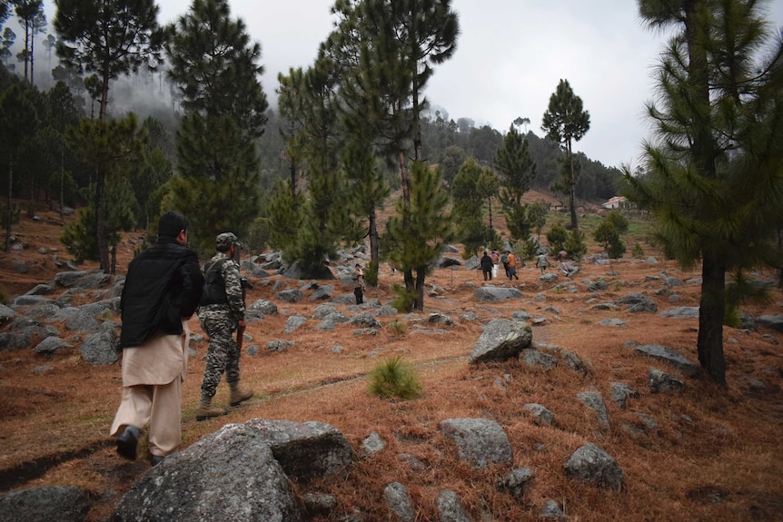 Pakistani reporters and troops visit the site of an Indian air strike in Jaba, near Balakot, Pakistan.