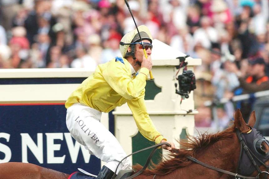 Damien Oliver salutes after winning 2002 Melbourne Cup