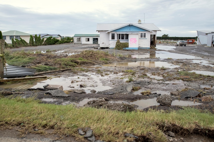 A house is surrounded by debris and floodwater in Hawkes Bay, New Zealand.