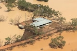 An outback homestead on an island of land surrounded by floodwater, as seen from the air