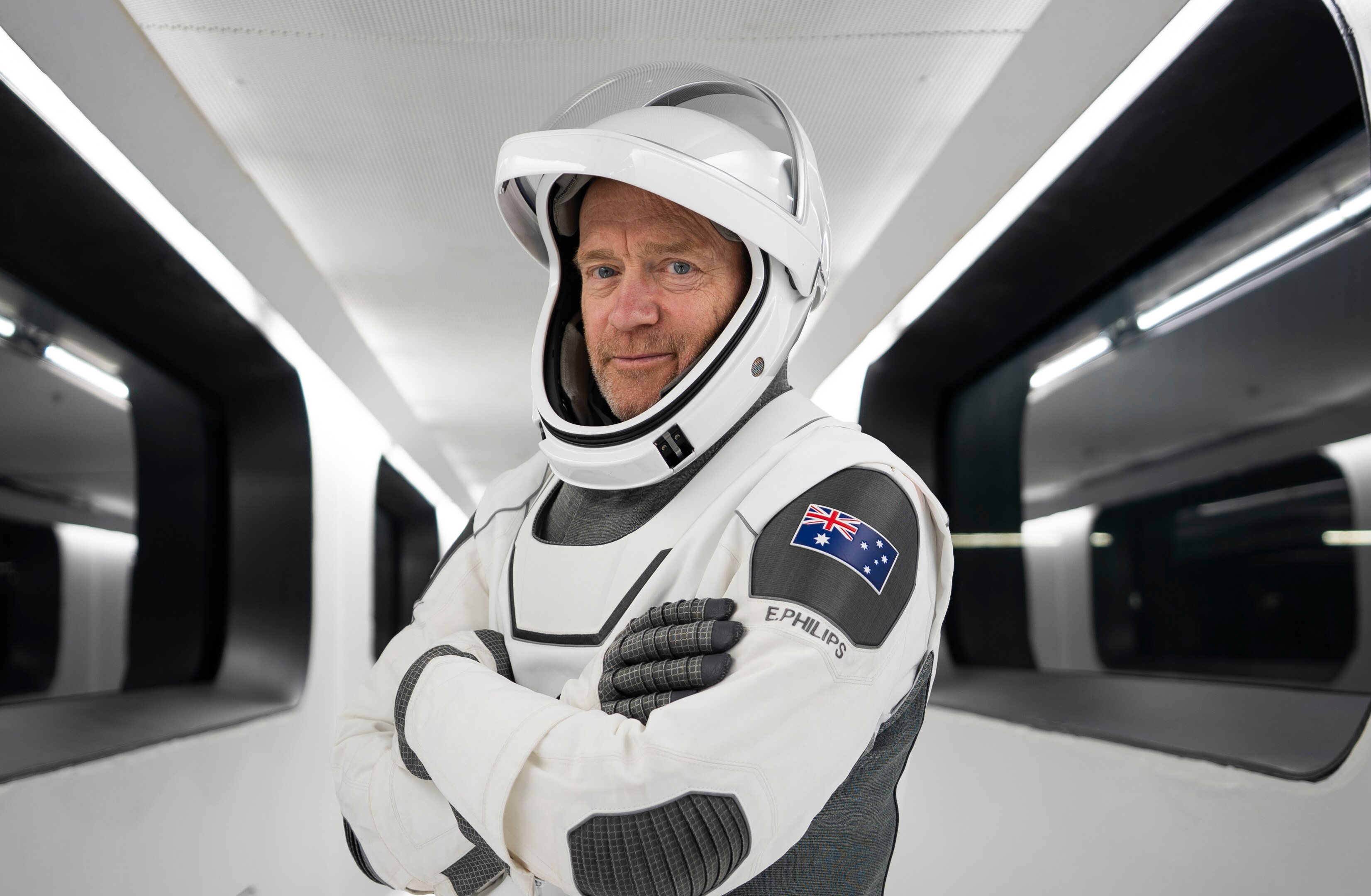 A man wearing a spacesuit, smiling.