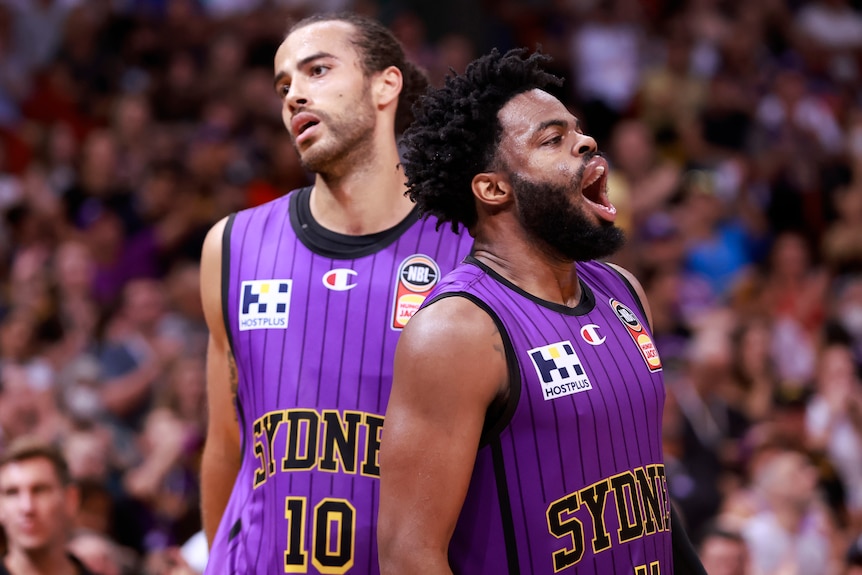 Two Sydney Kings NBL players stand next to each other during game three of the grand final series.