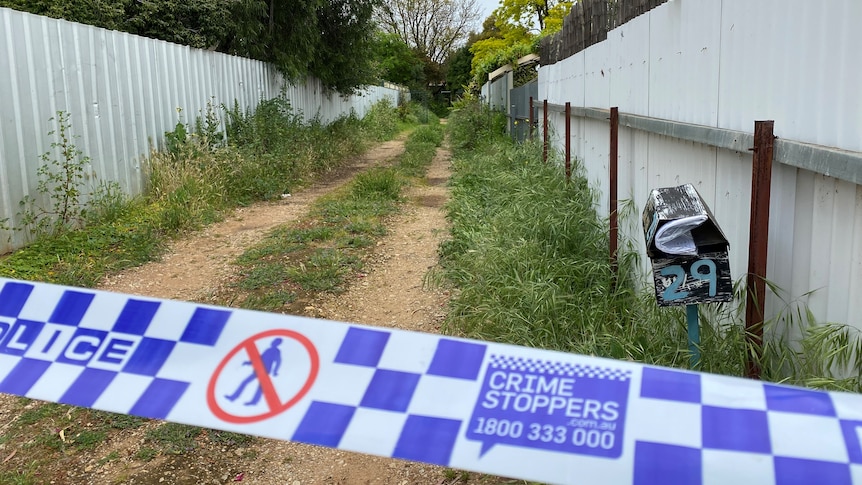 Crime scene tape across a driveway