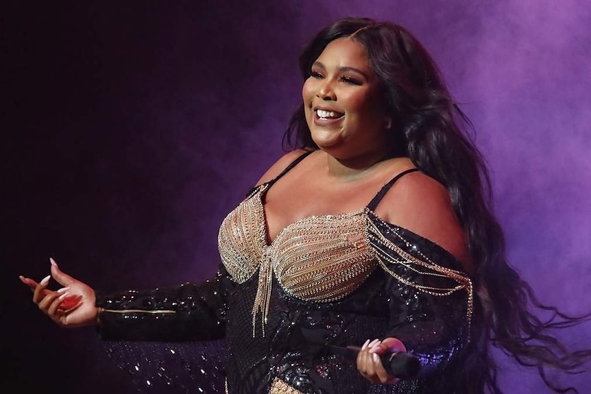 Lizzo smiles on stage