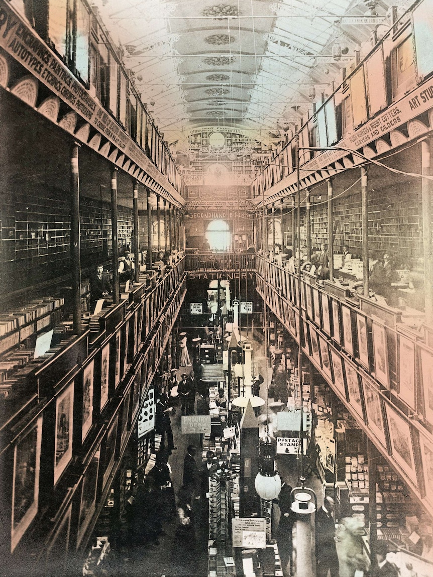 Black and white photo of an arcade stacked with millions of books.