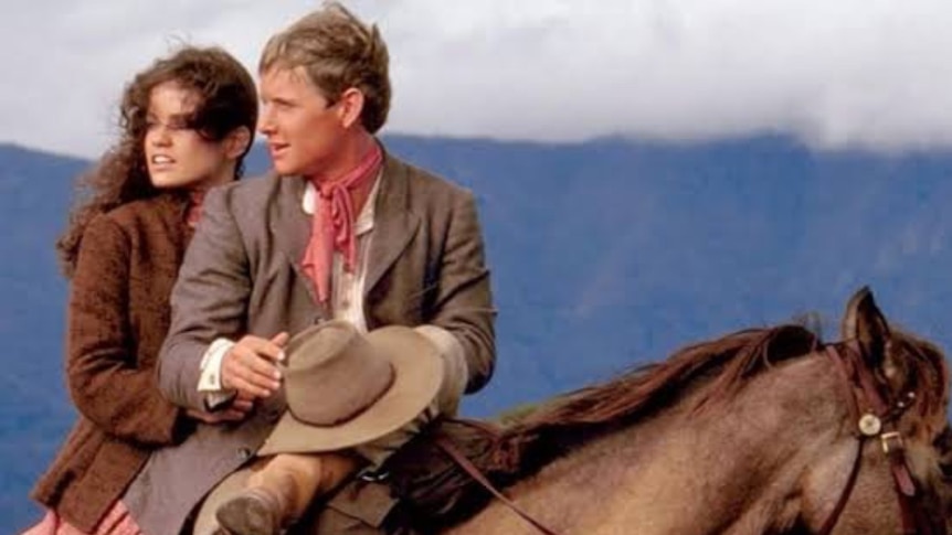 Lead characters from the film The Man from Snowy River sitting on a horse in the mountains.