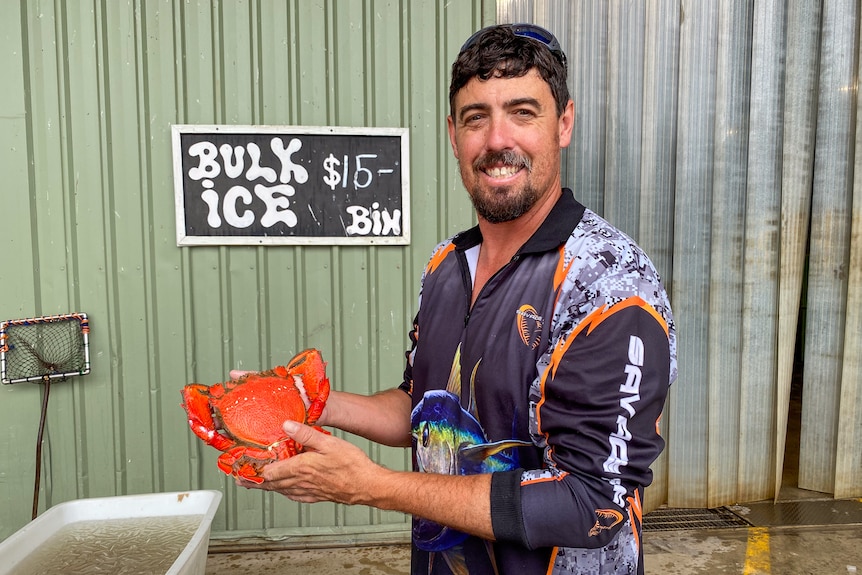 un homme tenant un crabe