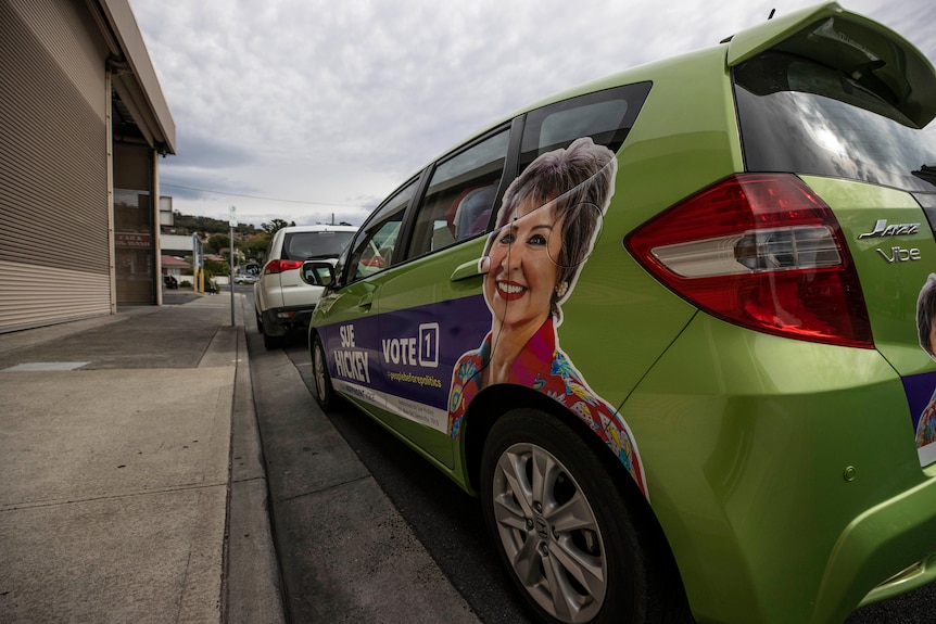 Vote 1 Sue Hickey sign on side of green car 