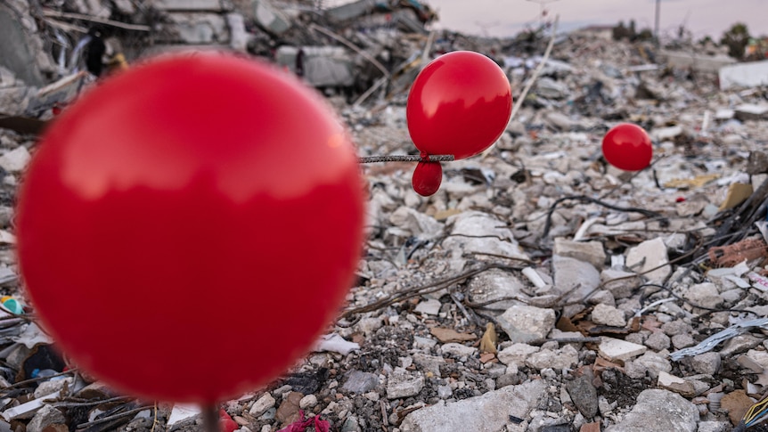 Balloons sit amongst the devastation caused by the earthquake in Antakya. 