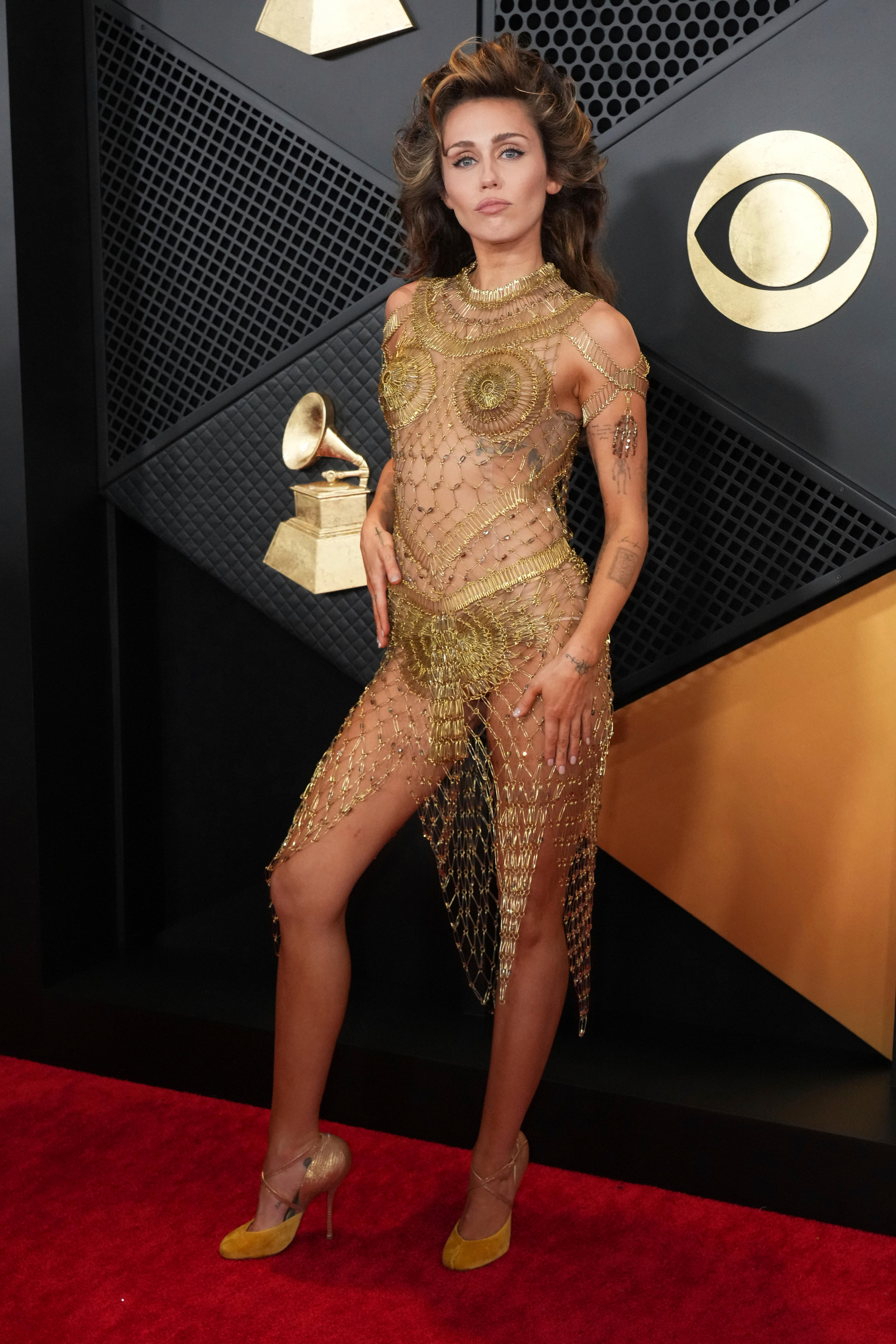 Miley Cyrus wearing a gold woven bodysuit