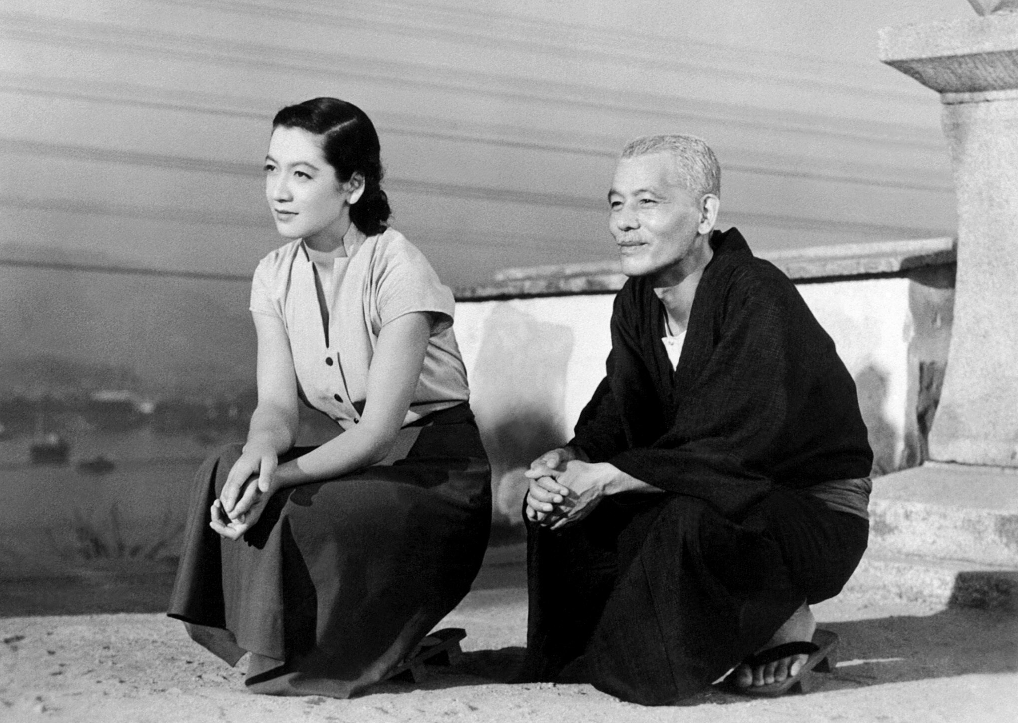 A black and white 1950s still of a young Japanese woman and an older Japanese man