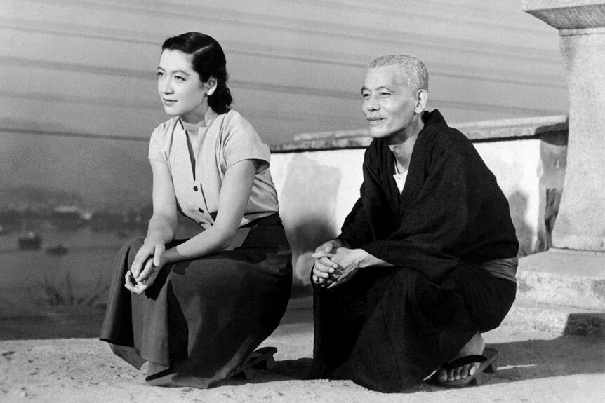 A black and white 1950s still of a young Japanese woman and an older Japanese man