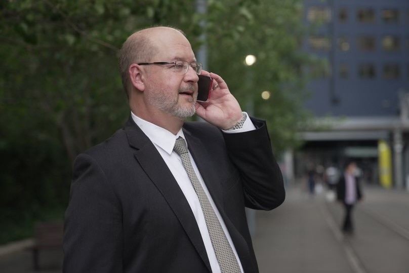 Warren Hogan habla por teléfono en el CBD de Sydney 