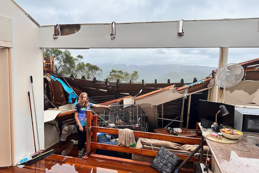 A woman stands in her storm damaged home in the Gold Coast hinterland
