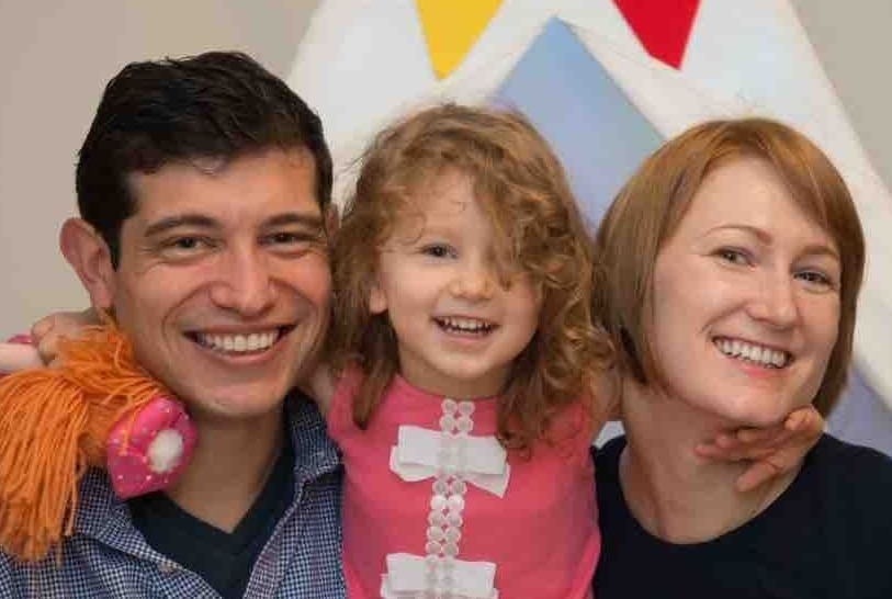 A man and woman holding a young girl.