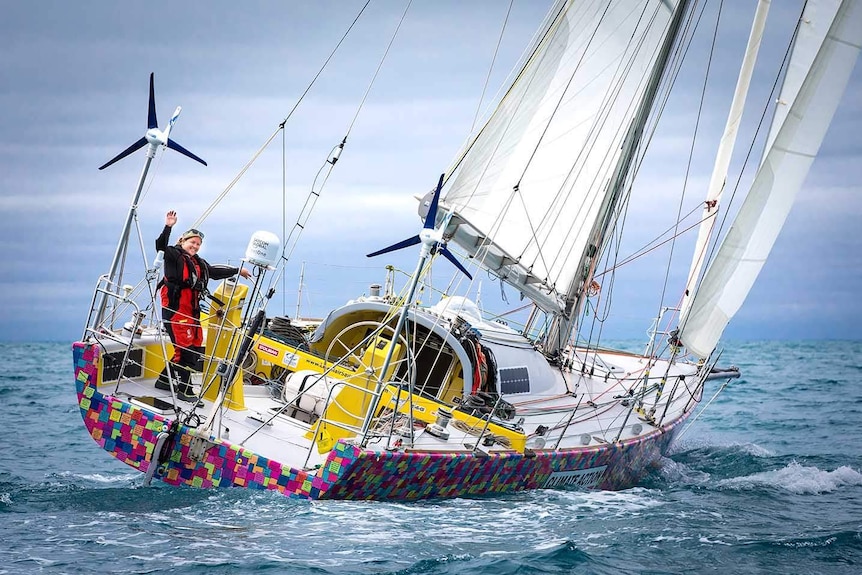 Solo sailor Lisa Blair waves from the back of her yacht Climate Action.