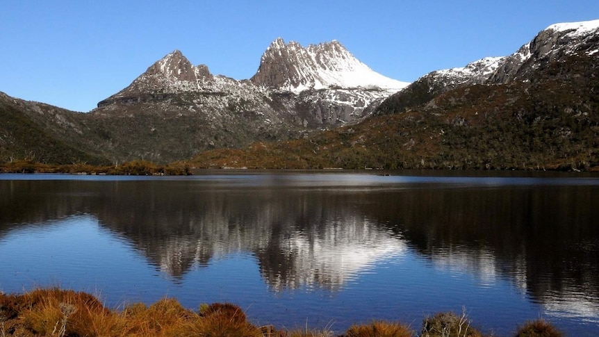 Snow on Cradle Mountain reflected in the water below