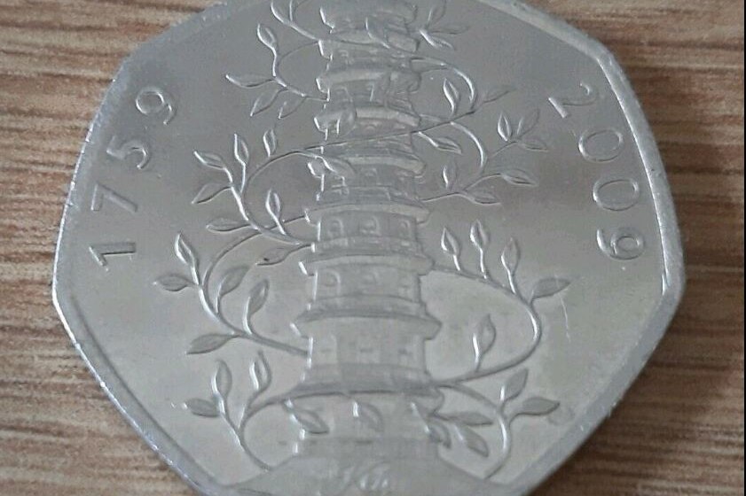 A coin showing a plant growing around a tower structure