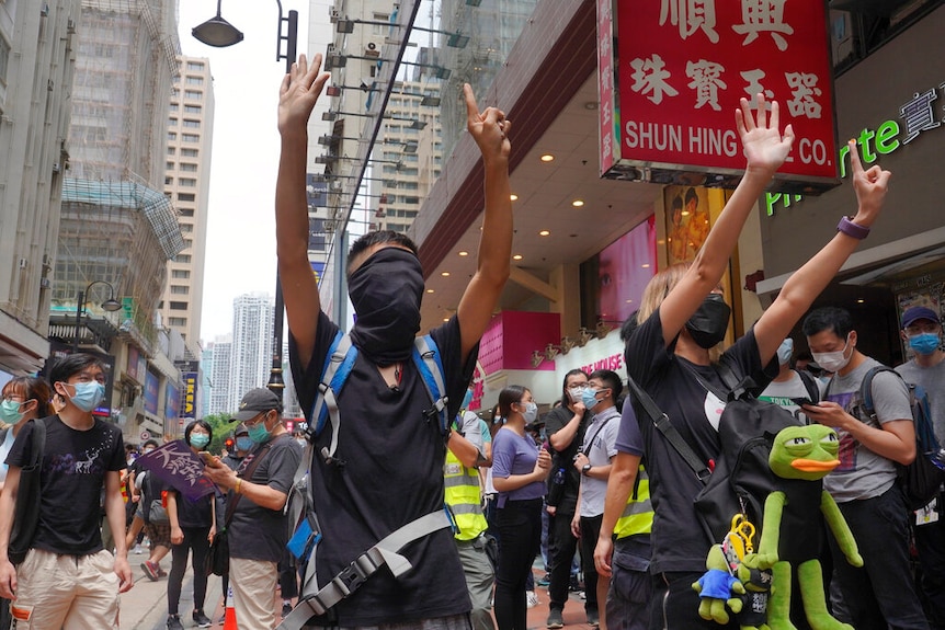 Protesters pictured gesturing five fingers amid a protests, signifying the five demands during a pro-democracy protest.