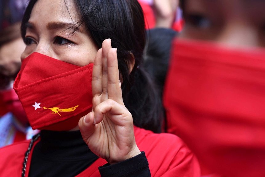 A Burmese woman holds the three-finger salute during a protest against the coup