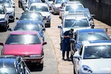 People in cars at a drive through testing clinic