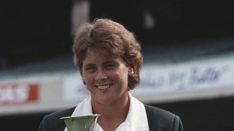 Former Australian cricket captain Lyn Larsen smiles for the camera as she holds the 1988 world cup.