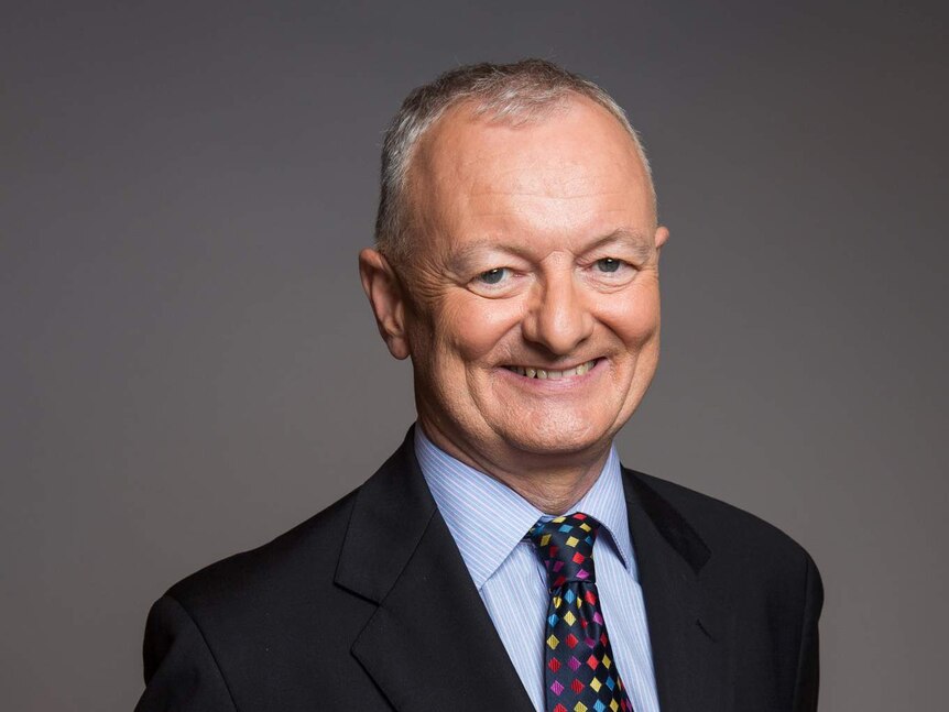 ABC election expert Antony Green smiles at the camera with his hands clasped behind his back.