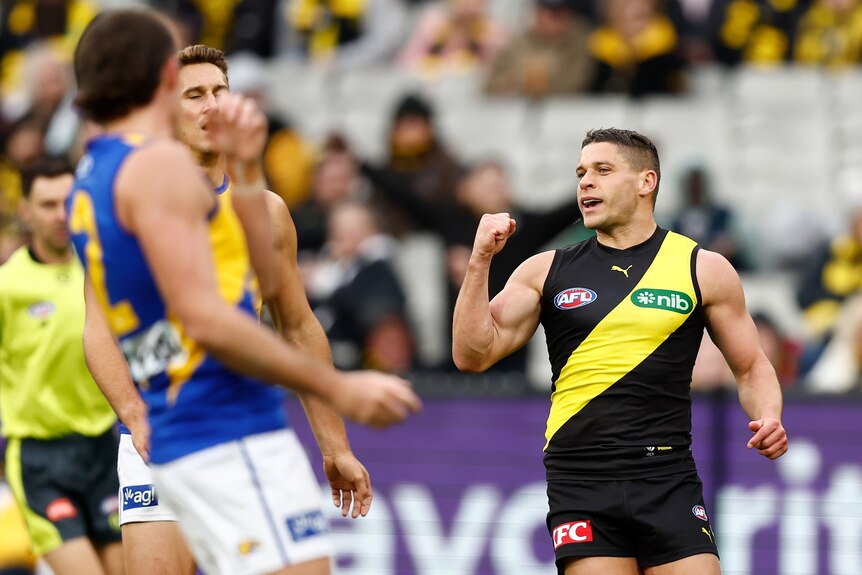 Dion Prestia pumps his fist in the vicinity of disappointed West Coast players