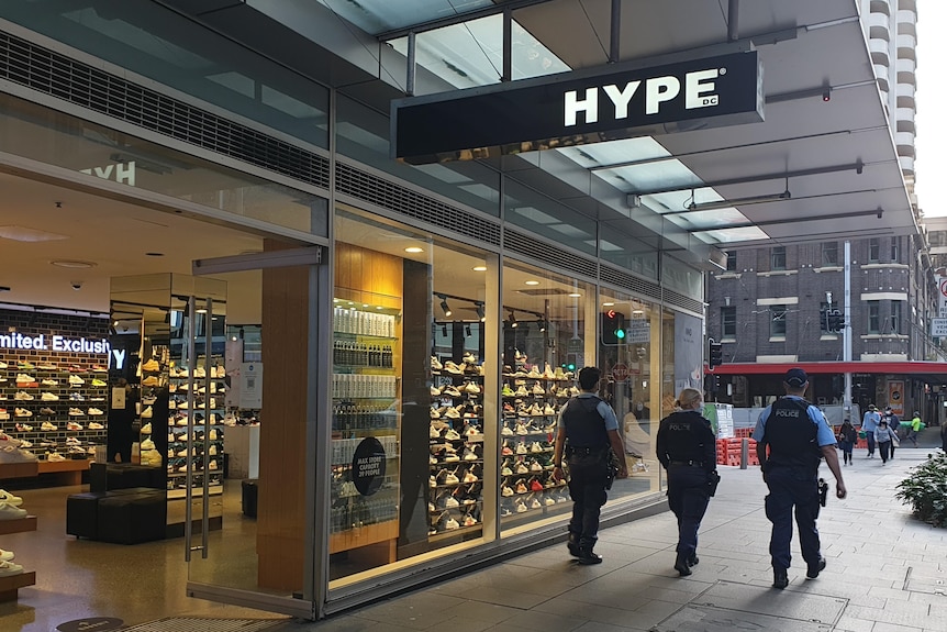 Police walk past a Hype DC store in the Sydney CBD.