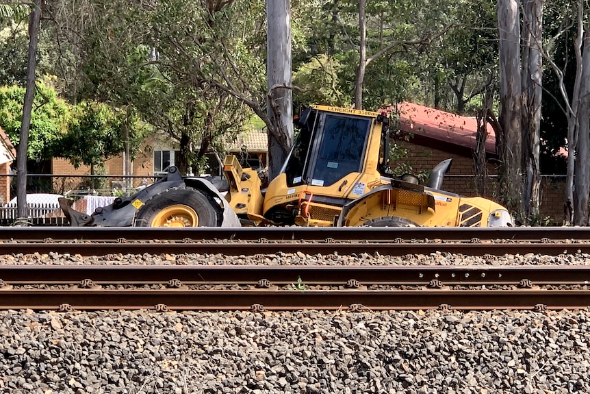 Excavator on train tracks.