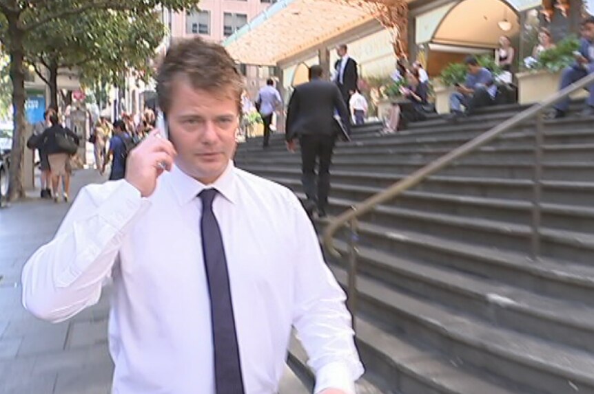 Mark Adamski outside the Downing Centre Local Court talking on the phone.