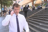 Mark Adamski outside the Downing Centre Local Court talking on the phone.